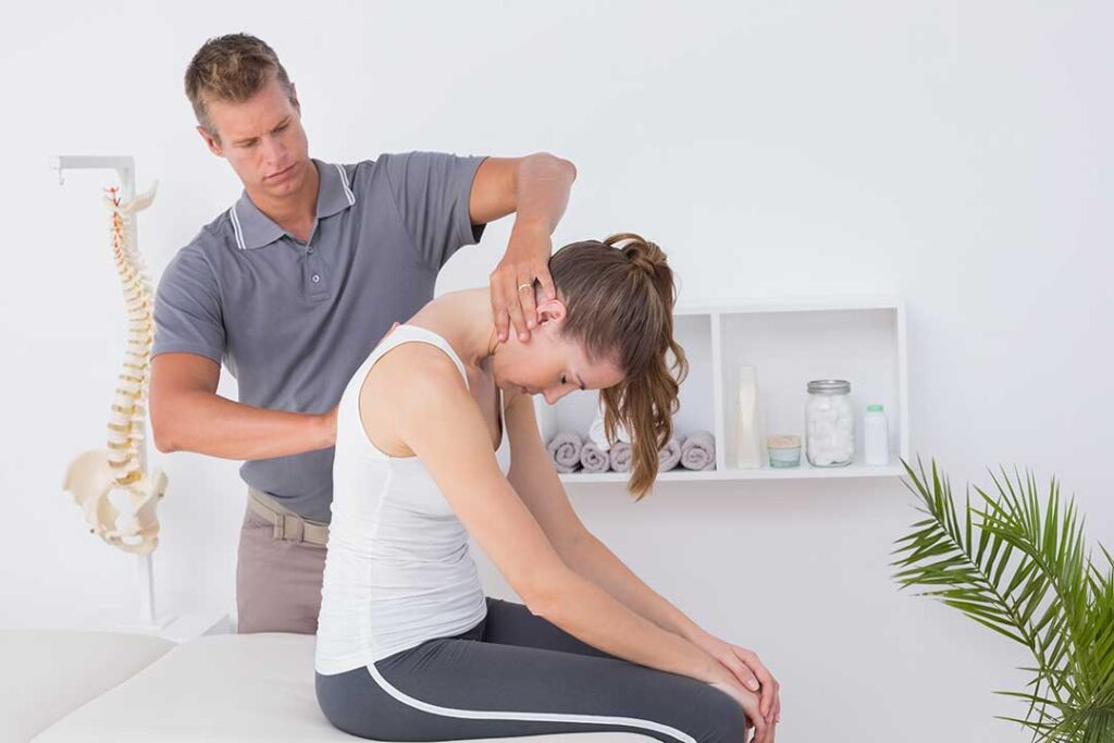 Person viewing a raised laptop at a desk while keeping the neck aligned and shoulders relaxed.